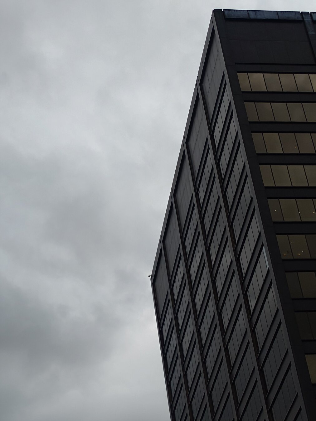 Dark, ominous skyscraper against a gloomy, cloyded sky