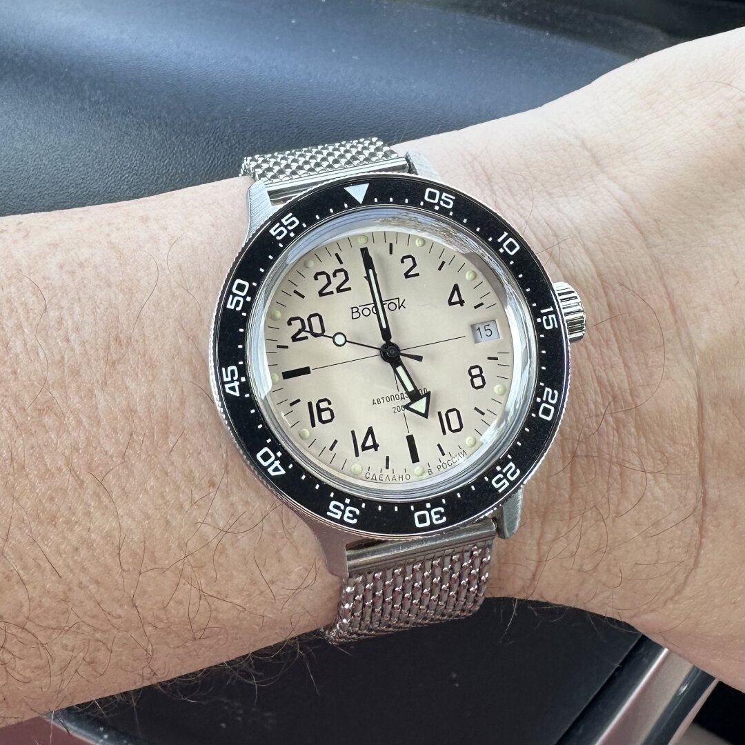 Watch with brushed stainless steel case, 24-hour cream-colored “sniper” dial, 3:00 crown, date window at 3:00 and black dive bezel marked in 5- minute increments on a polished Milanese mesh strap.