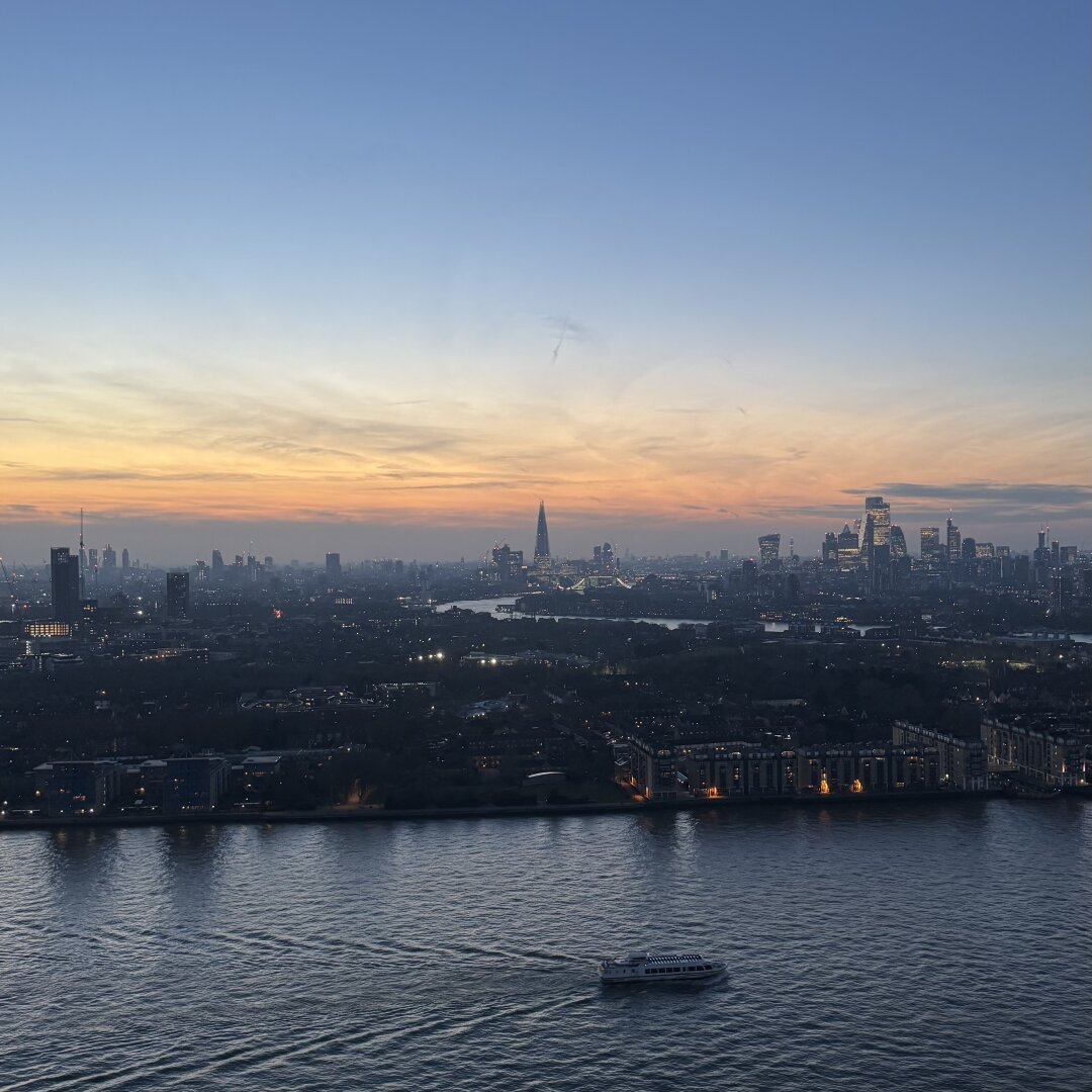 The view from my apartment in Canary Wharf in London. Facing west over the river Thames we can see the shard in the centre of the picture as the Sun goes down over the city. A river taxi is passing by in the foreground.