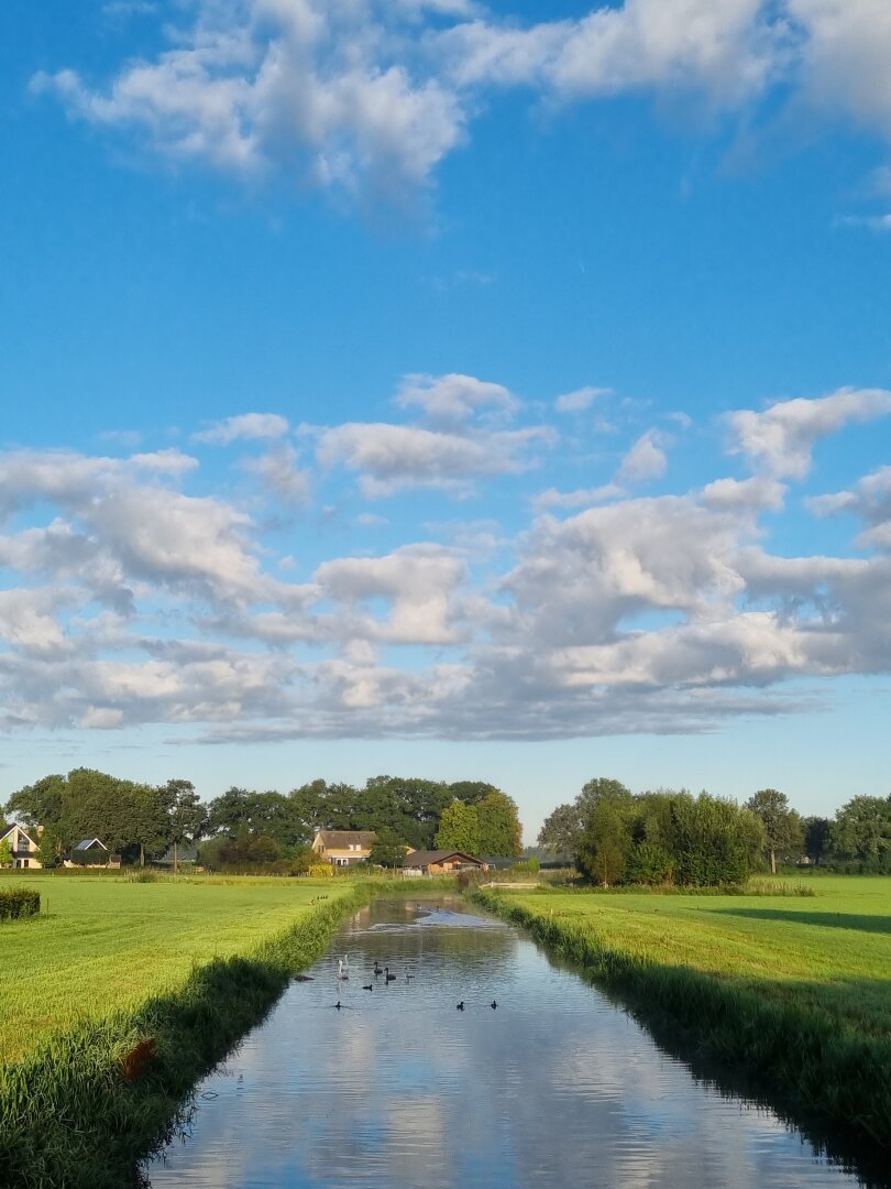 Rivier de Leijgraaf met een blauwe lucht en kleine wolkjes erboven.