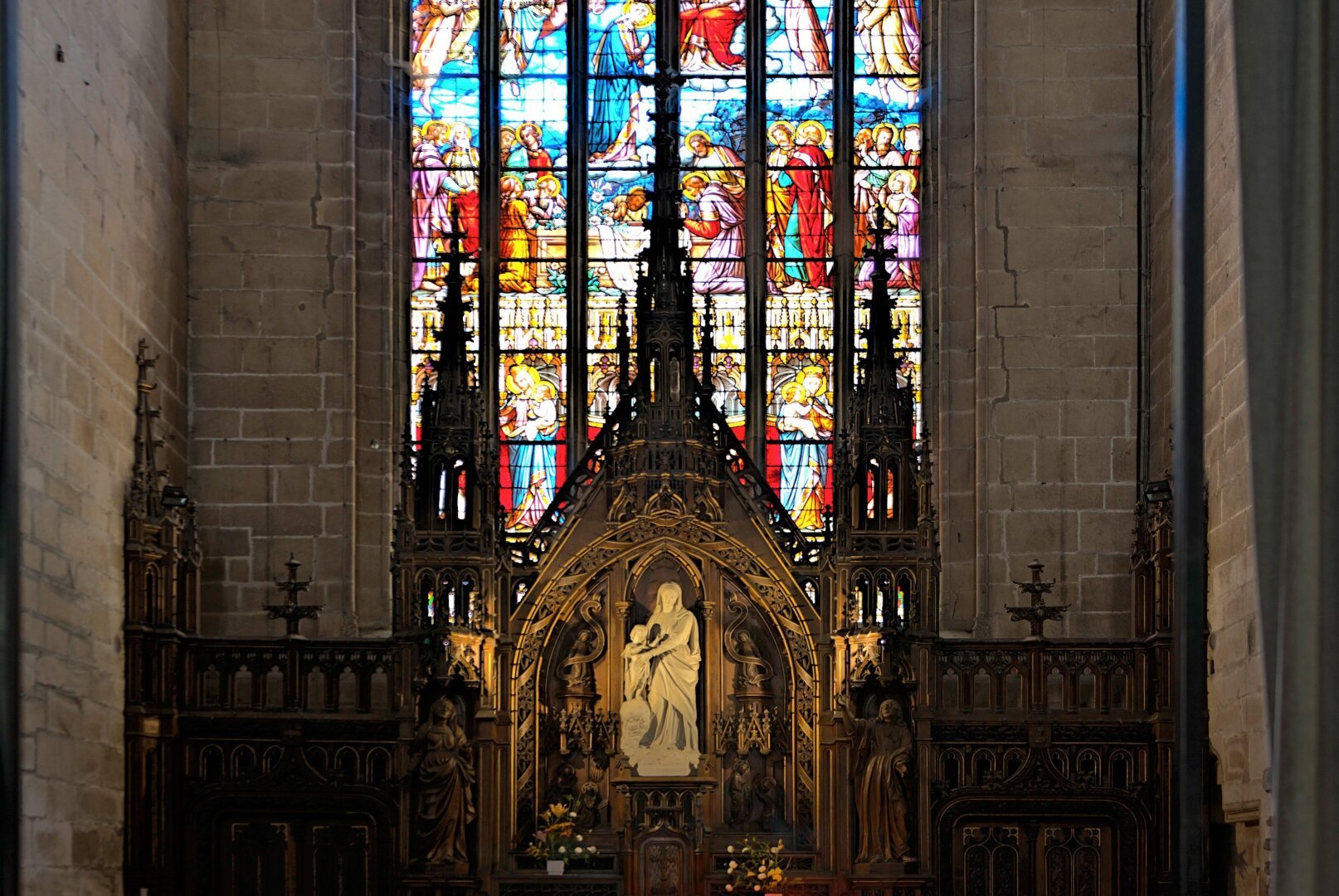 retable devant un vitrail dans une église en Bretagne.