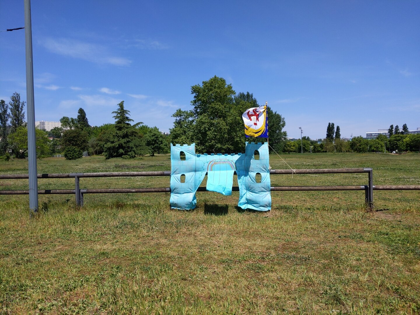 un château en tissu turquoise avec un drapeau dans un parc