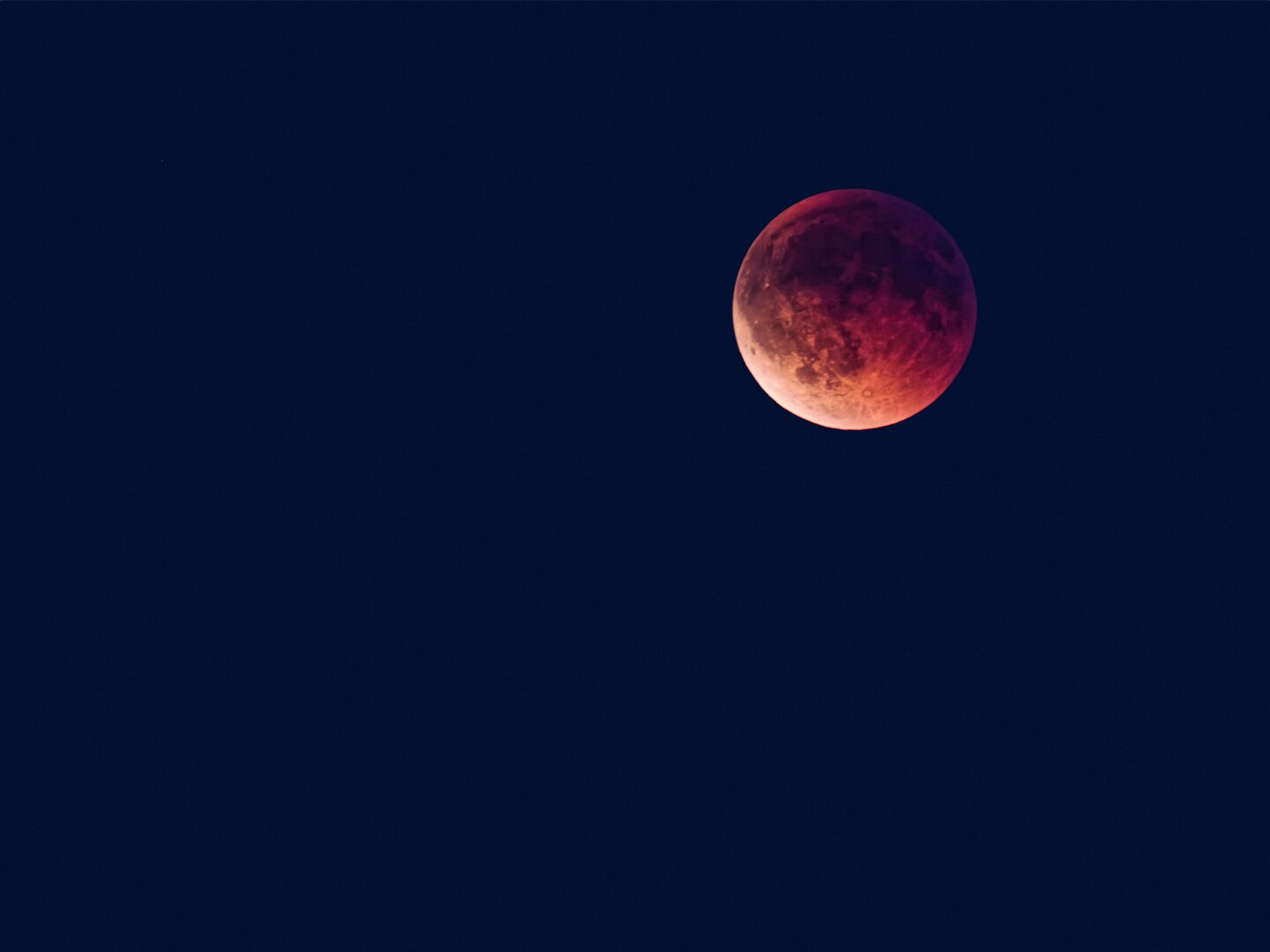 A detailed photograph of a blood moon during a lunar eclipse, glowing in deep red and orange hues against a dark night sky. A detailed photograph of a blood moon during a lunar eclipse, glowing in deep red and orange hues against a dark night sky.