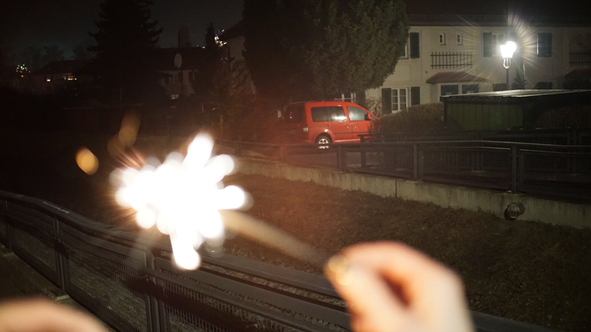 brennende Wunderkerze - rotes Auto im Hintergrund