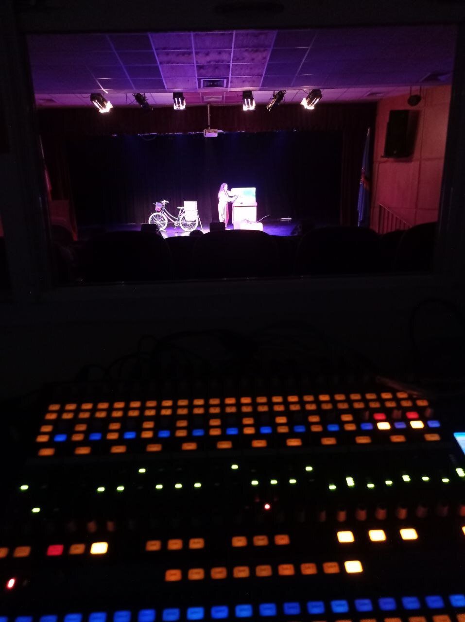 consola de sonido digital en primer plano. escenario iluminado al fondo