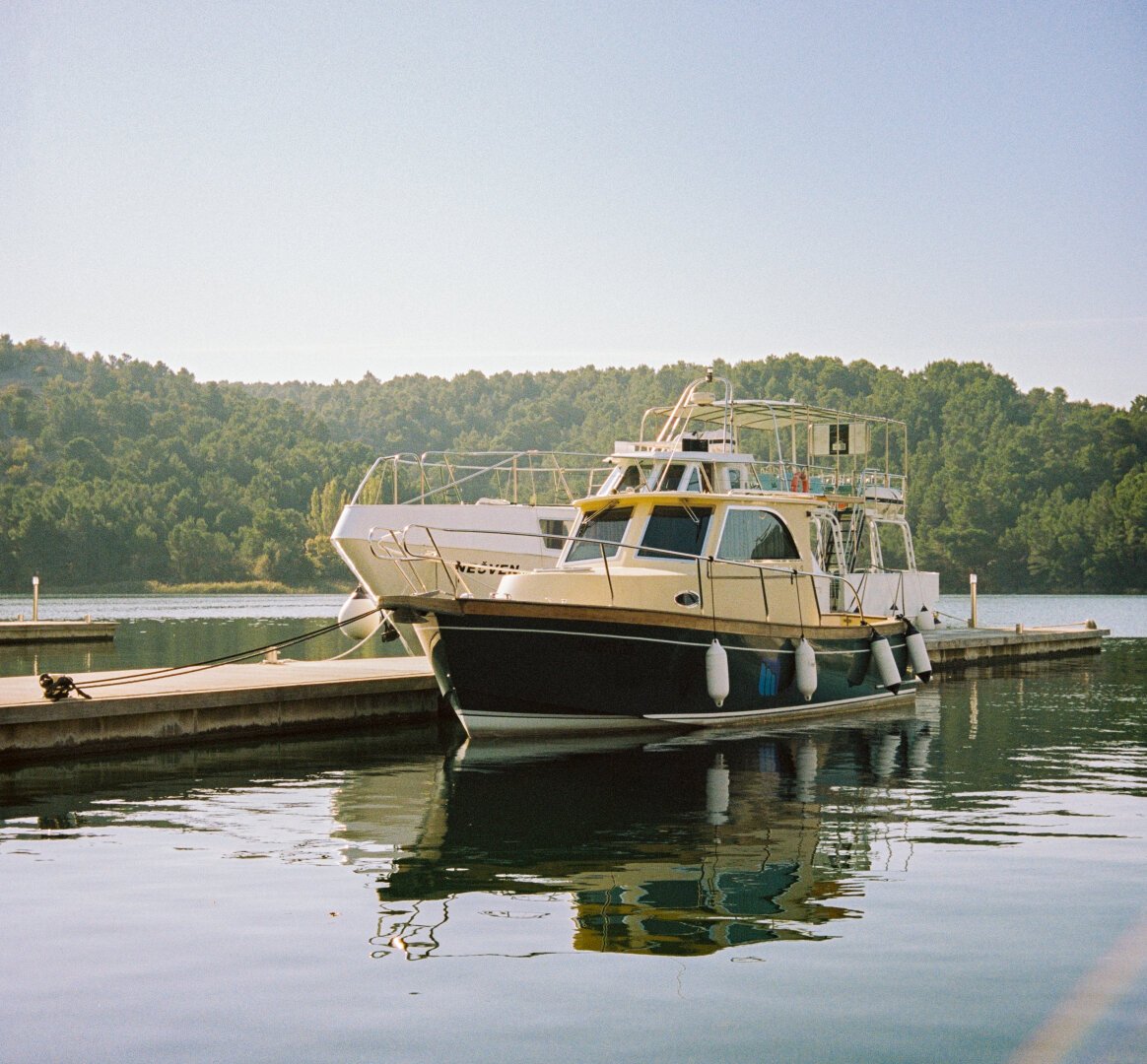 Boat on the lake, forest in the background, lots of sunshine