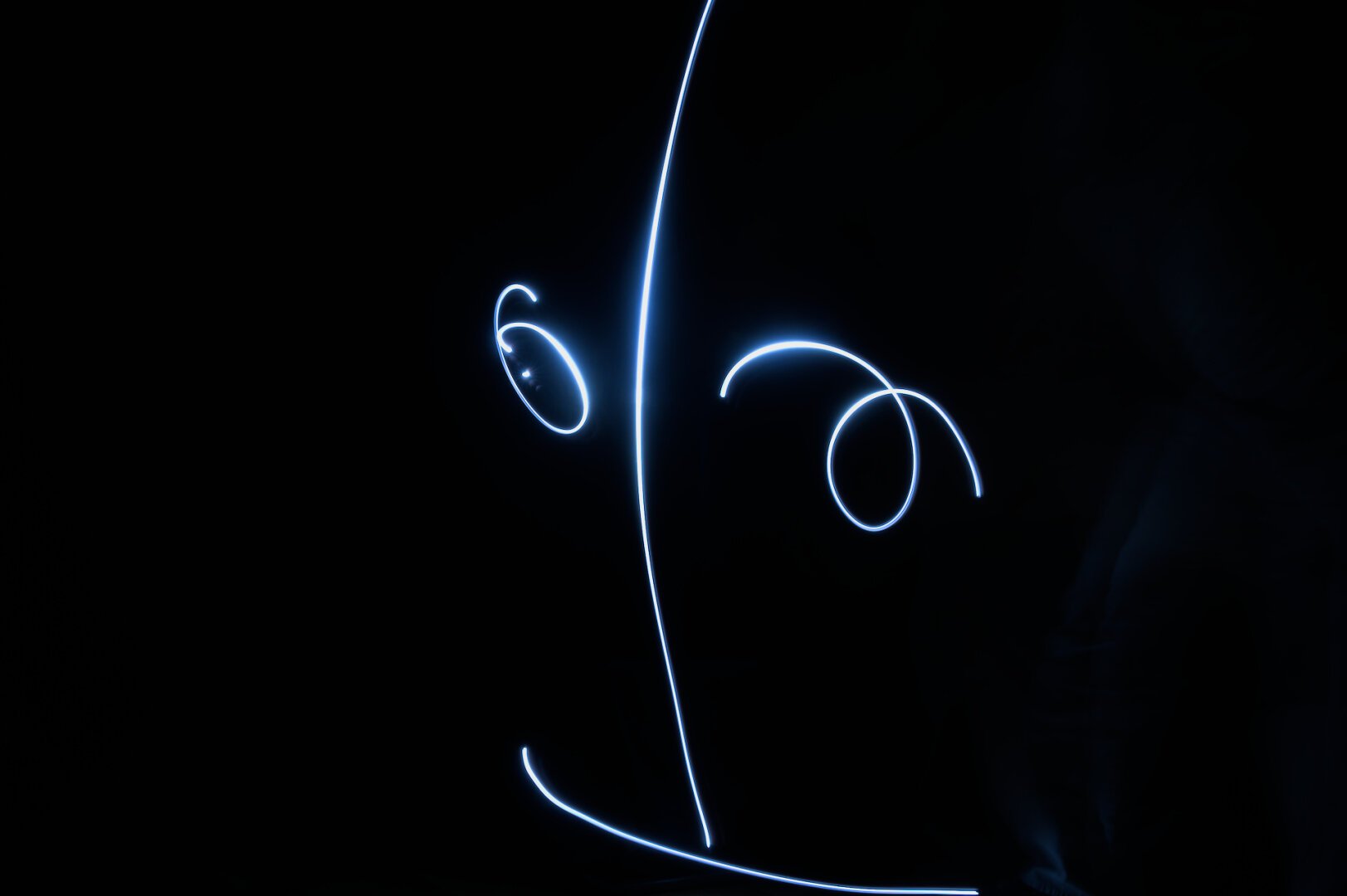 Traces lumineuses qui forment un visage avec un sourire