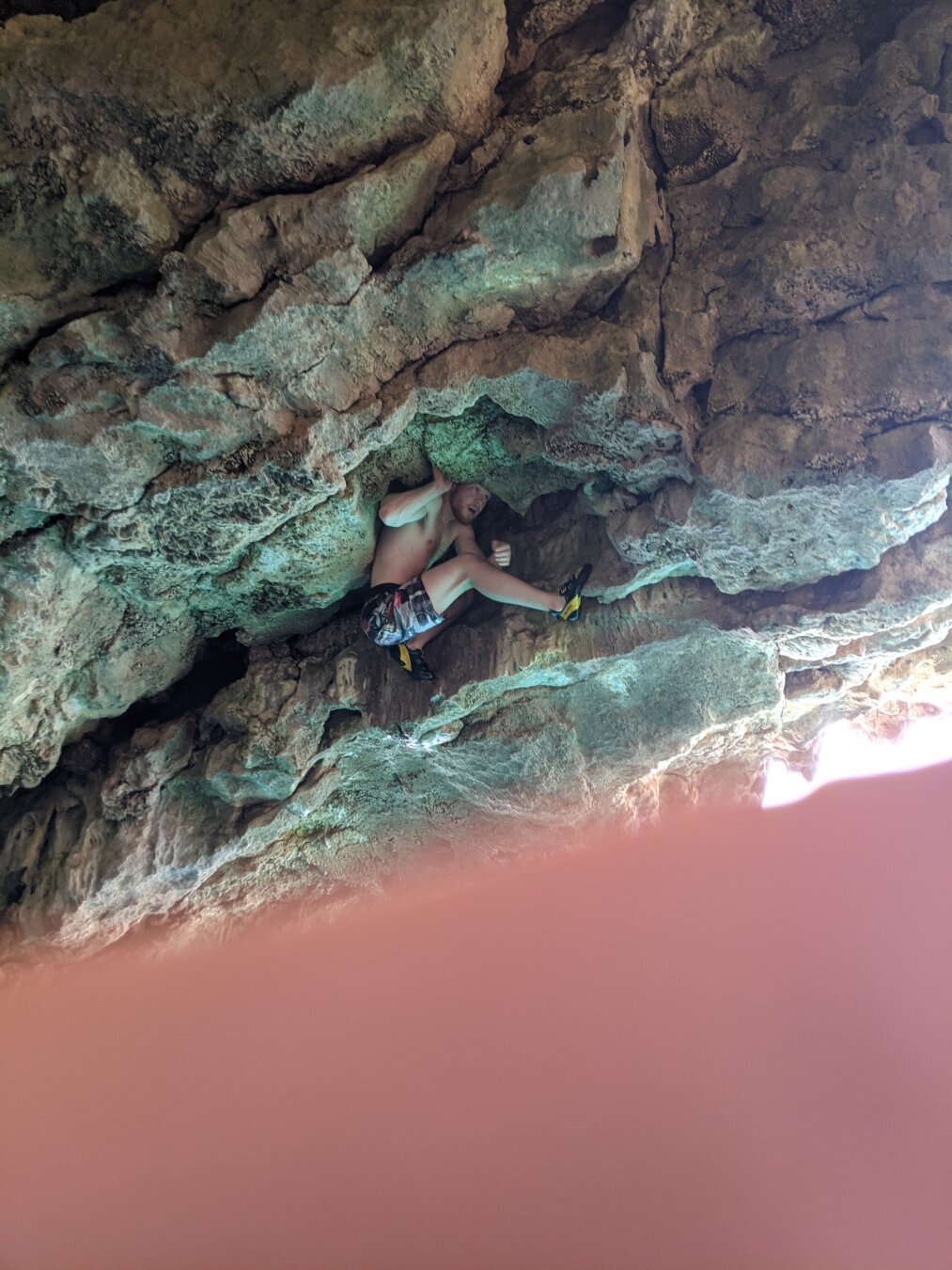 A man climbing the roof of the cave found a poisition for rest just under the ceiling and had to bend into half to fit the spot.