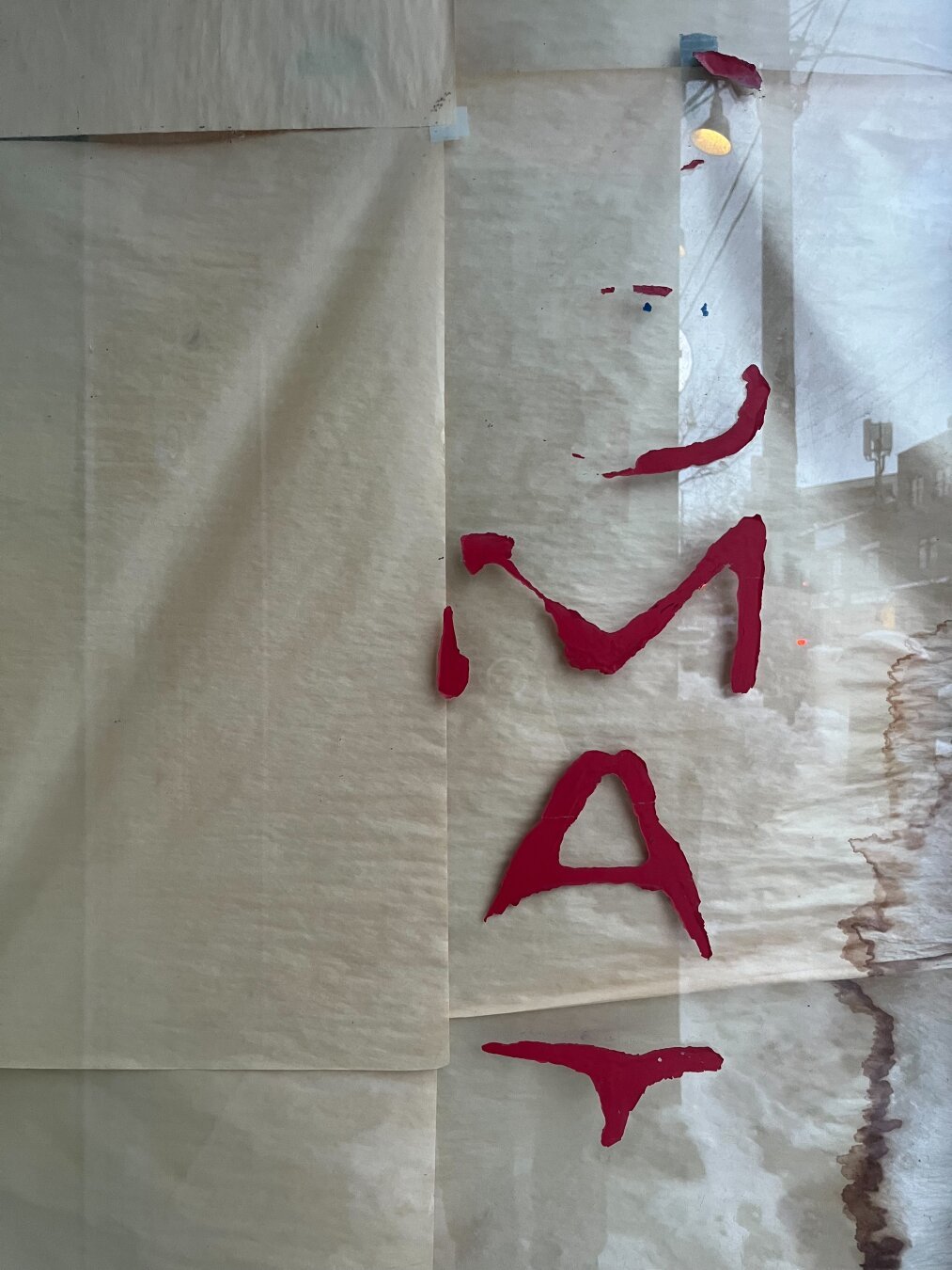 Close up of laundry mat front window with faded lettering in red.