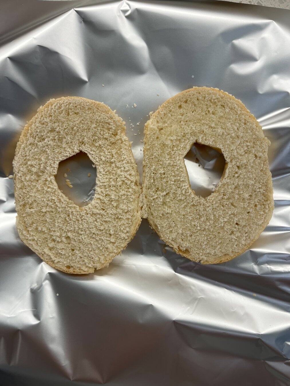 Bagel on tin foil, vertical crop.