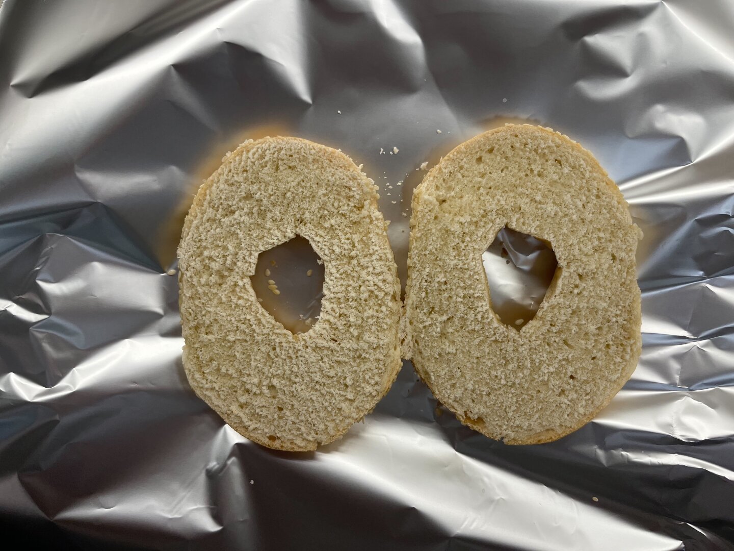 Bagel on tinfoil, horizontal crop.