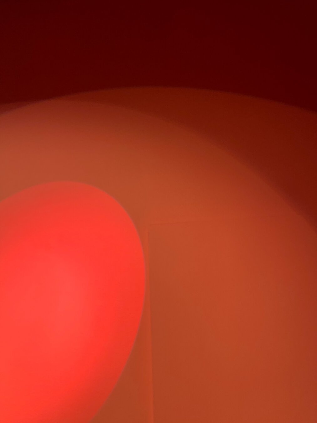 Shadows of two spotlights. Salmon reds of the hues of the lights on the wall.