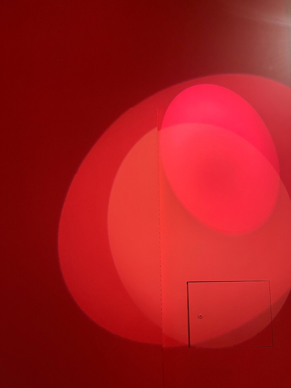 Spotlight shadows. Different shades of reds, different shapes on the wall, more of egg shapes.