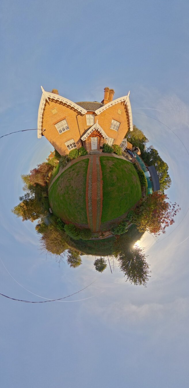 360 image adapted to a 'tiny planet'. A house floating in a blue sky that surrounds the building.