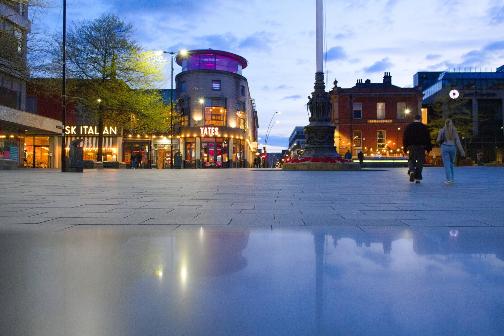 barkers pool in sheffield, photo taken at dusk with the camera sitting on a marble bench reflecting some images