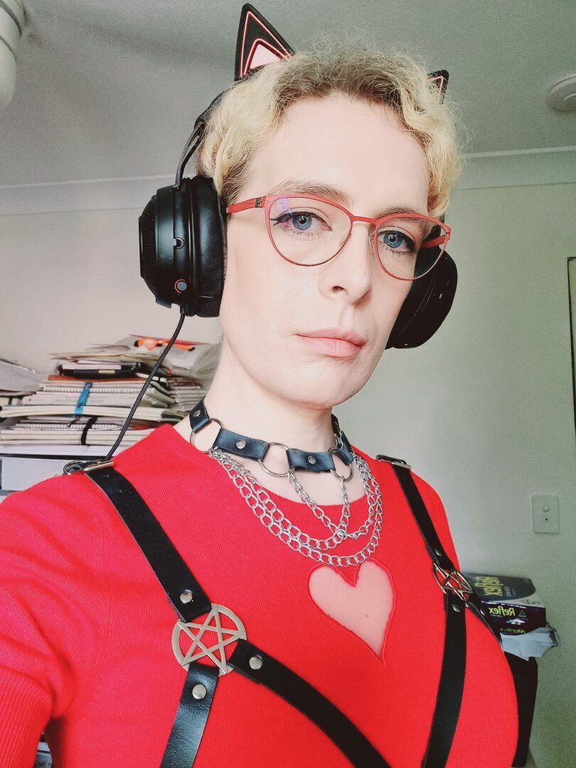 Woman in red top and harness with earphones