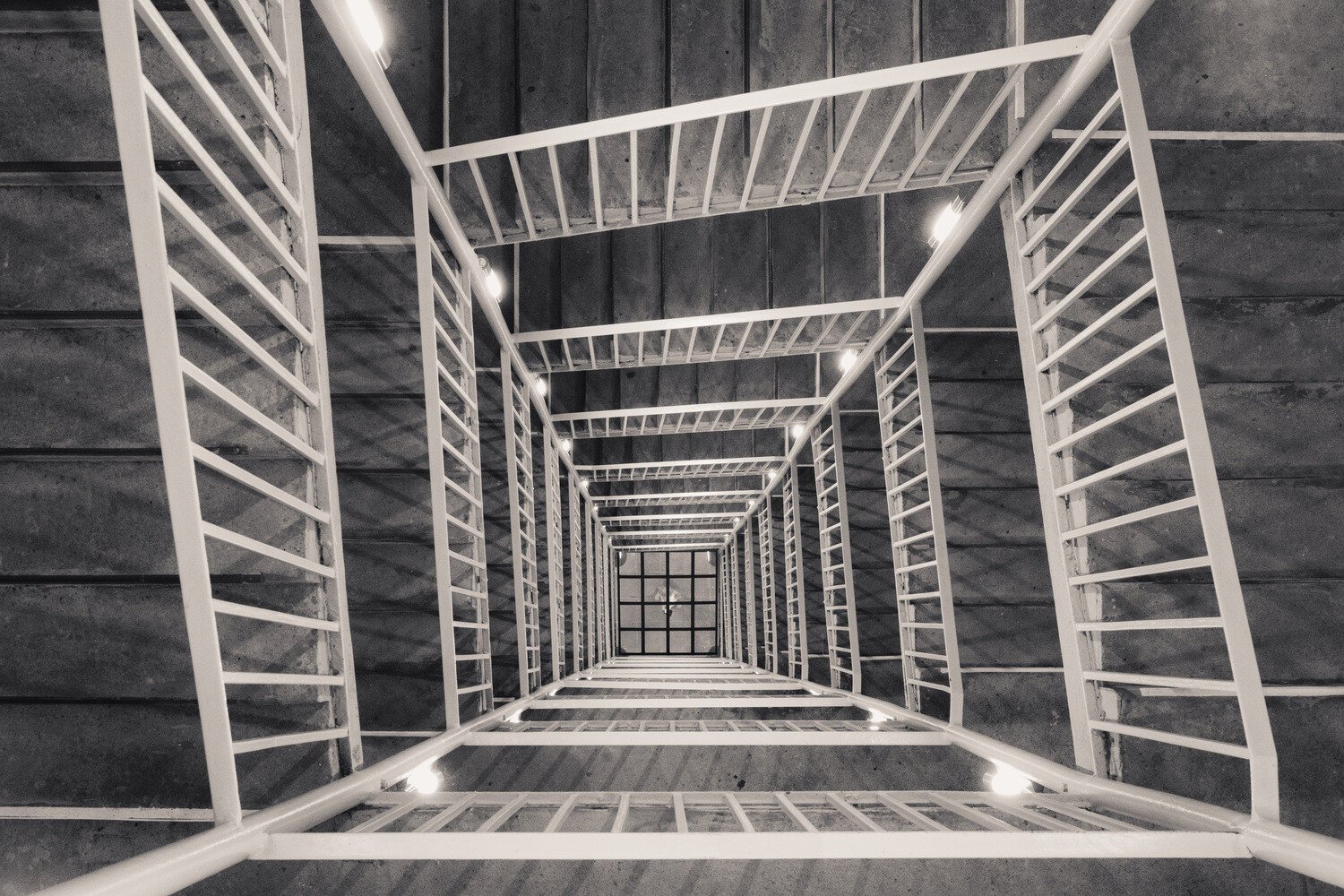 A monochrome photo of a staircase photographed from above.