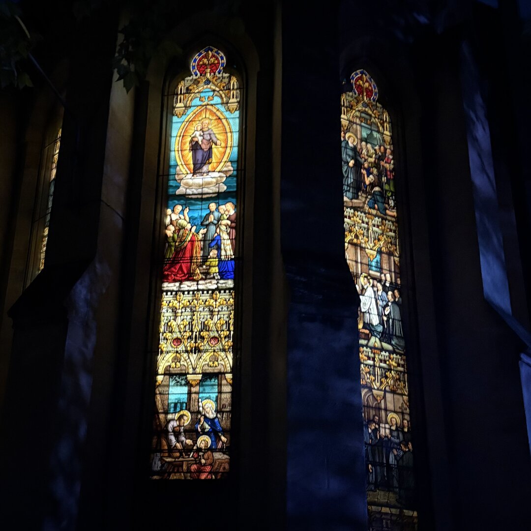 Vitraux d'une chapelle éclairées en pleine nuit. Vue de l'extérieur.
