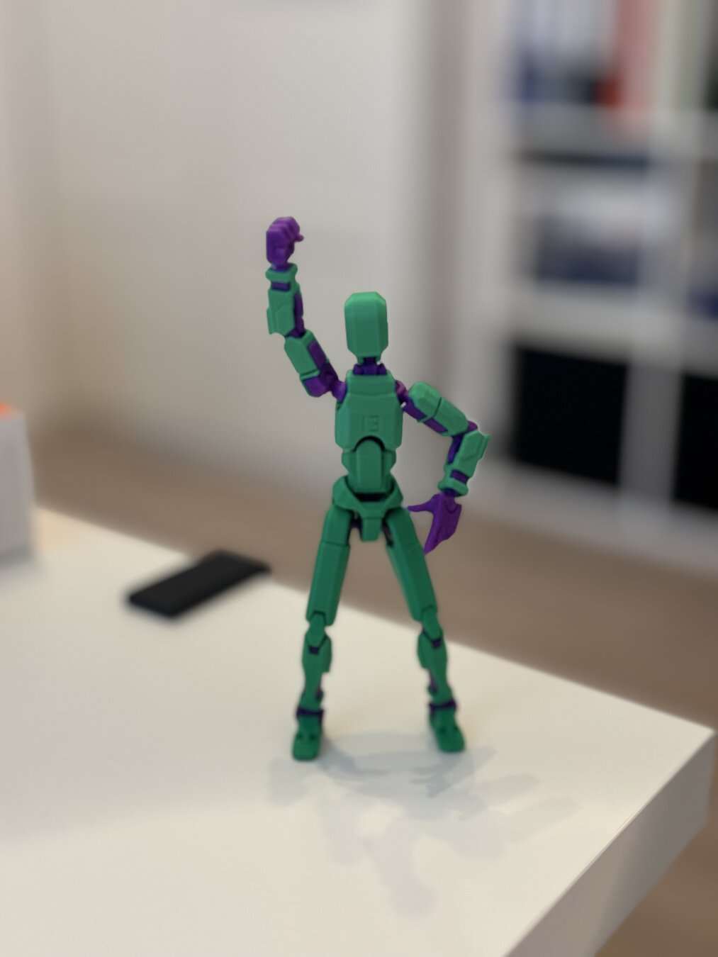 A 3D printed action figure in green and purple colors