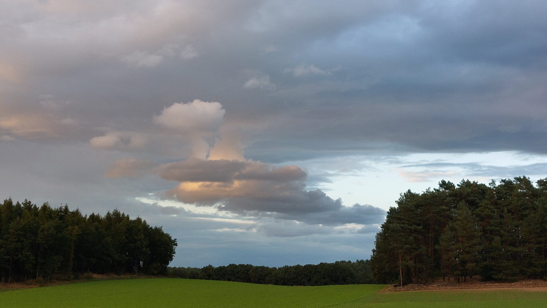 Clouds forming the bottom tubes of the starship Enterprise with a hint of a top circle and a bright light in the clouds.