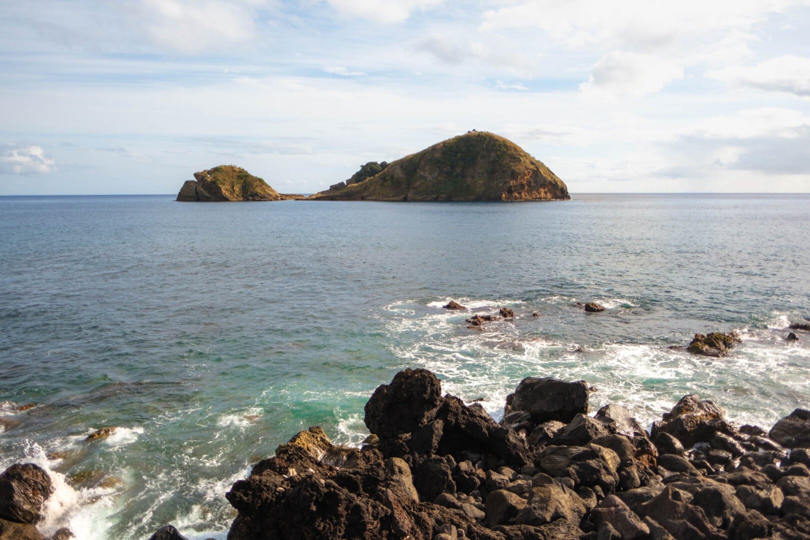 a rocky shore with a small island in the middle