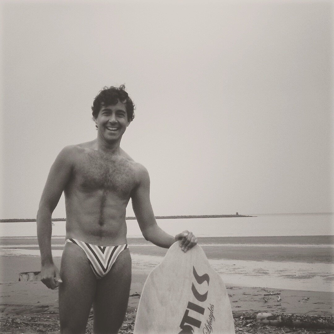 selfie, at the beach holding a skimboard