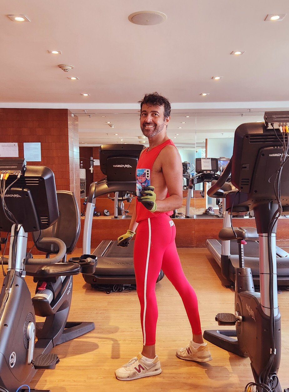 Gym mirror selfie. Wearing red workout gear.