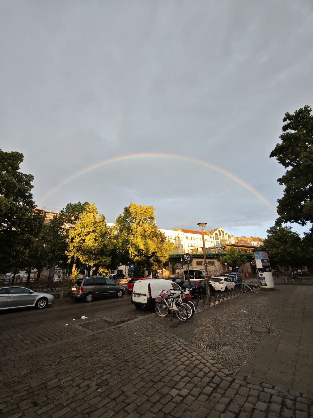 Man sieht eine Straße und einen perfekten Regenbogen
