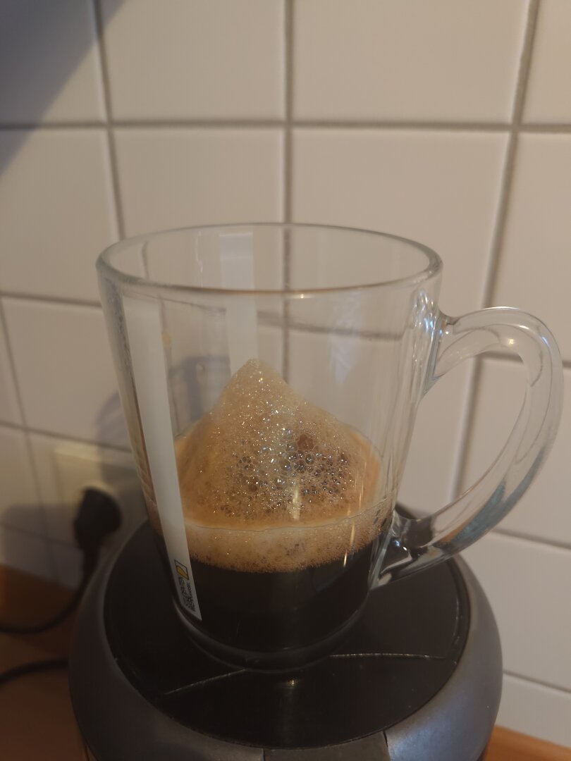 Coffe cup with foam in a peaky hill shape