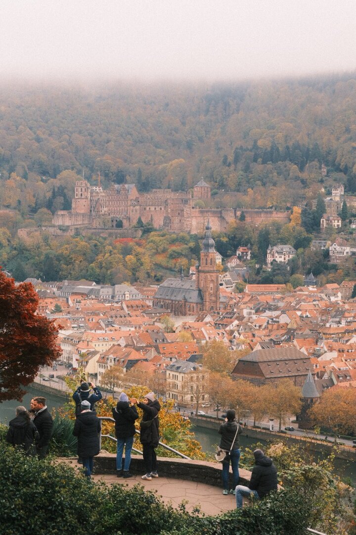 A few tourists admire the city below from a high standpoint.