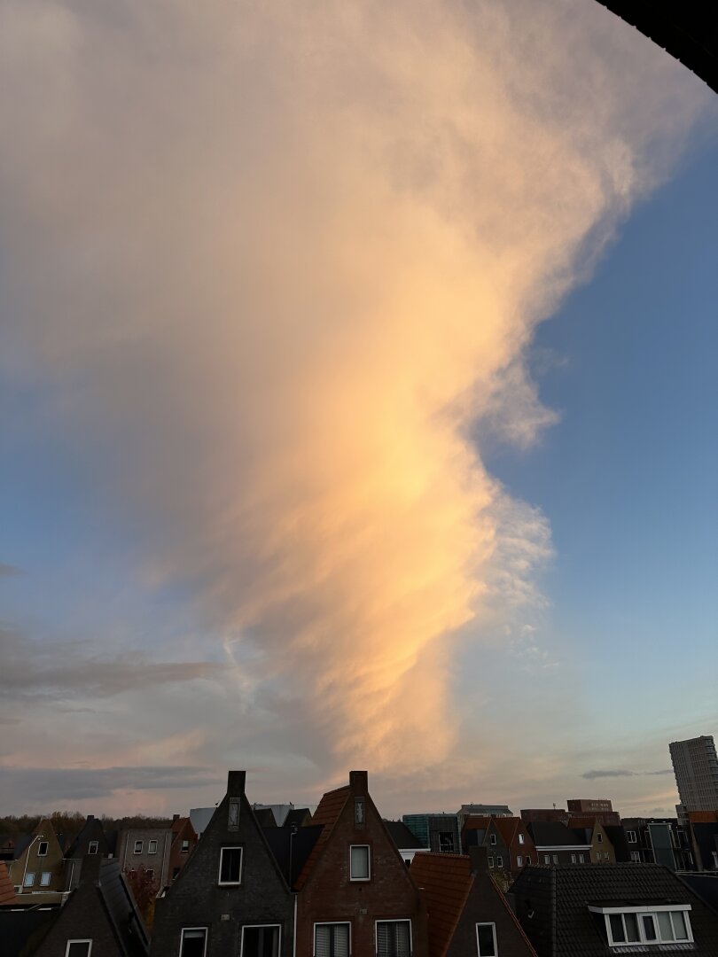 Photo of a cloud during sunset that twists around on itself, resulting in the illusion of a tornado.