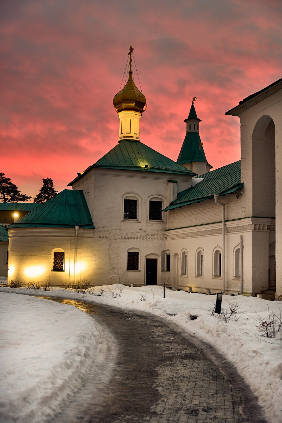 The red sunset behind the church at winter.