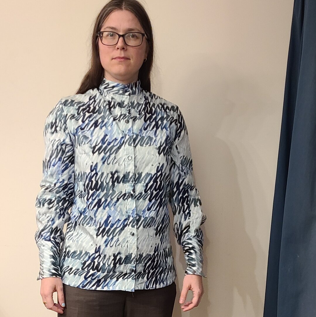 A woman wearing a shirt with a geometric scribble pattern