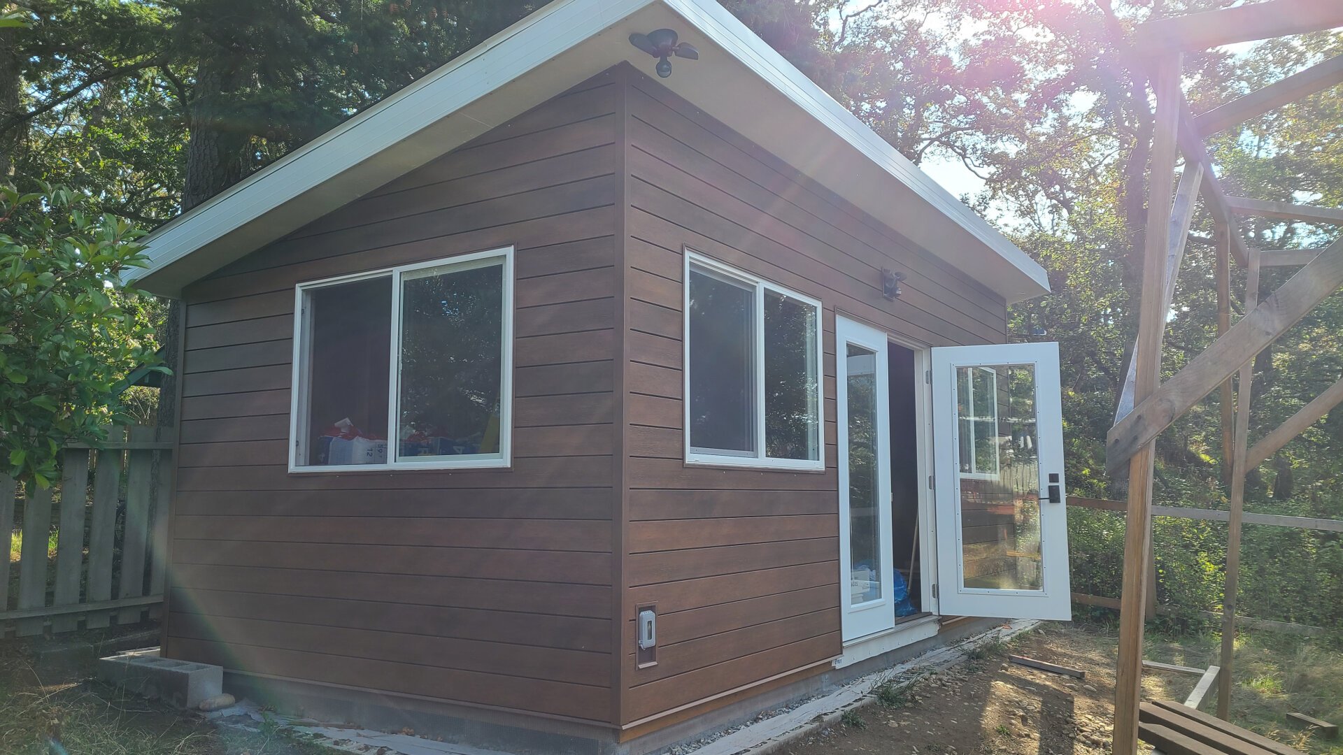 A shed with a slopped roof, the windows, and French doors.