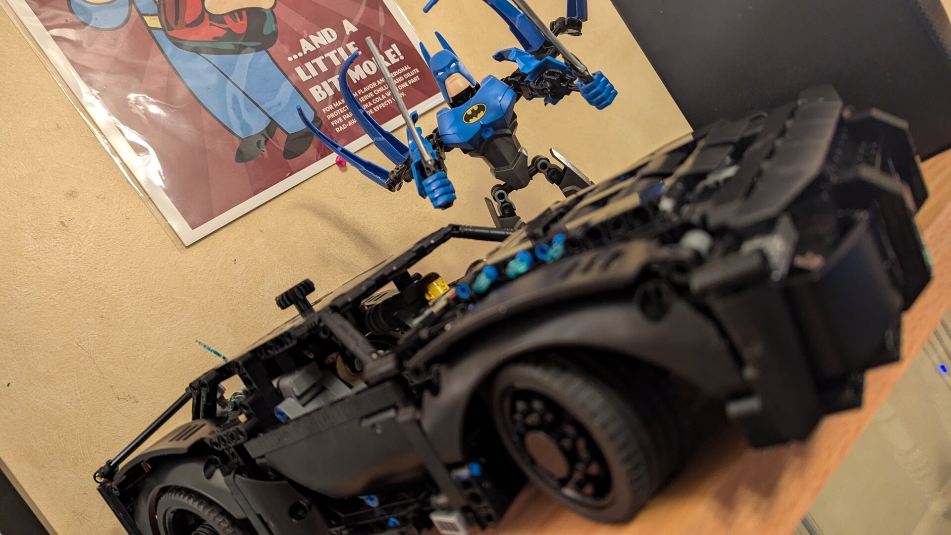 The Batmobile Technic set from The Batman movie with a blue LEGO Batman behind it.