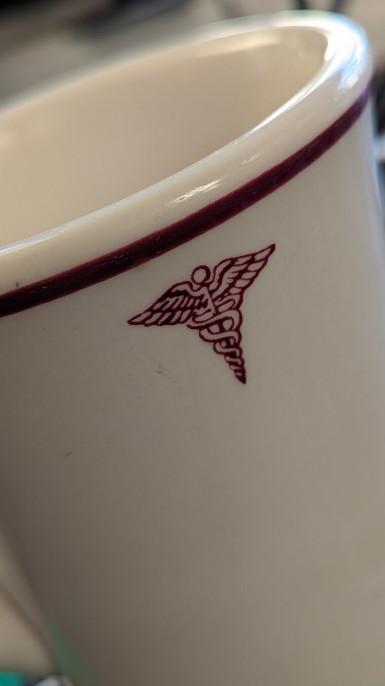 The medical symbol on a heavy ceramic naval medical mug.