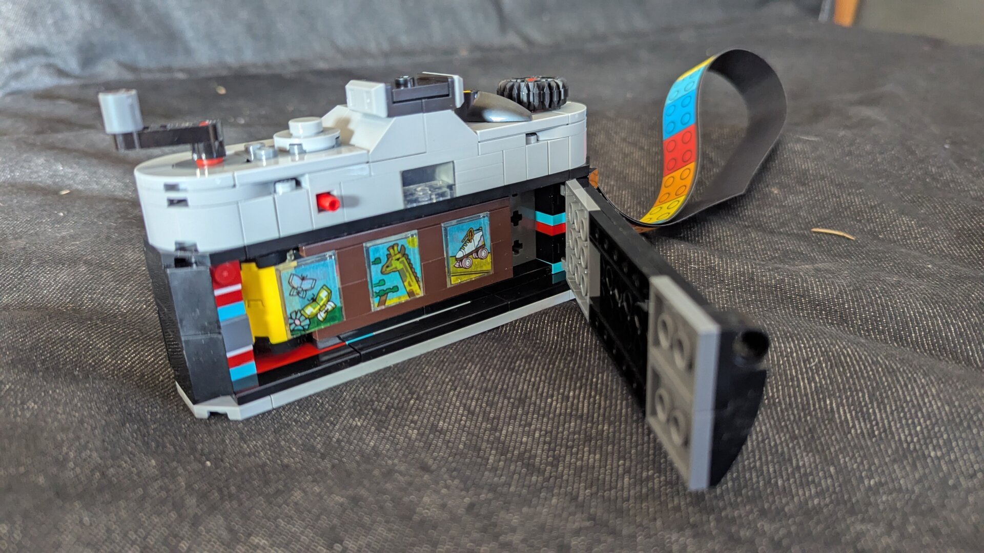 Lego film camera from the back, with the back open and Lego film in it.