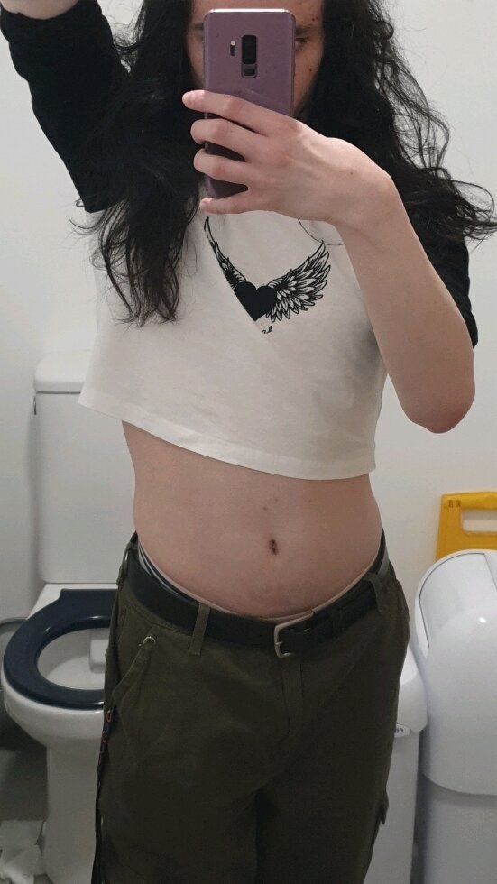 Mirror selfie of me wearing a crop top and trousers