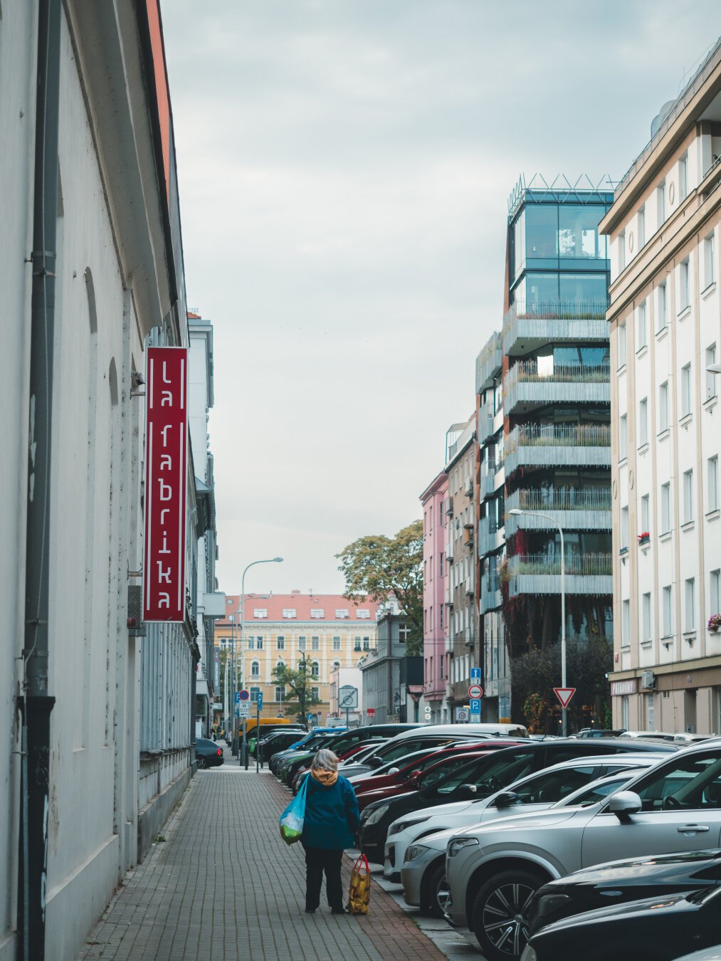 Photo of a street with modern looking buildings and cars parked