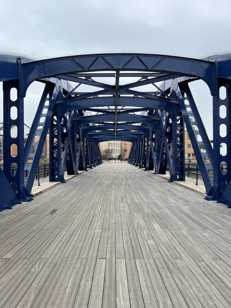 Blue steel bridge with wooden boards.