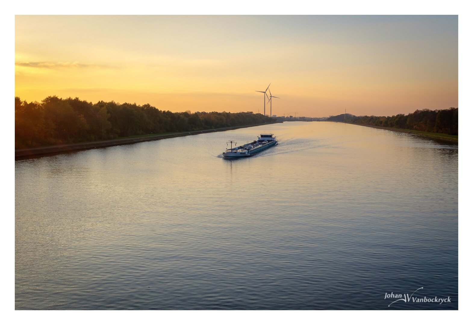 A boat on a canal during sunset