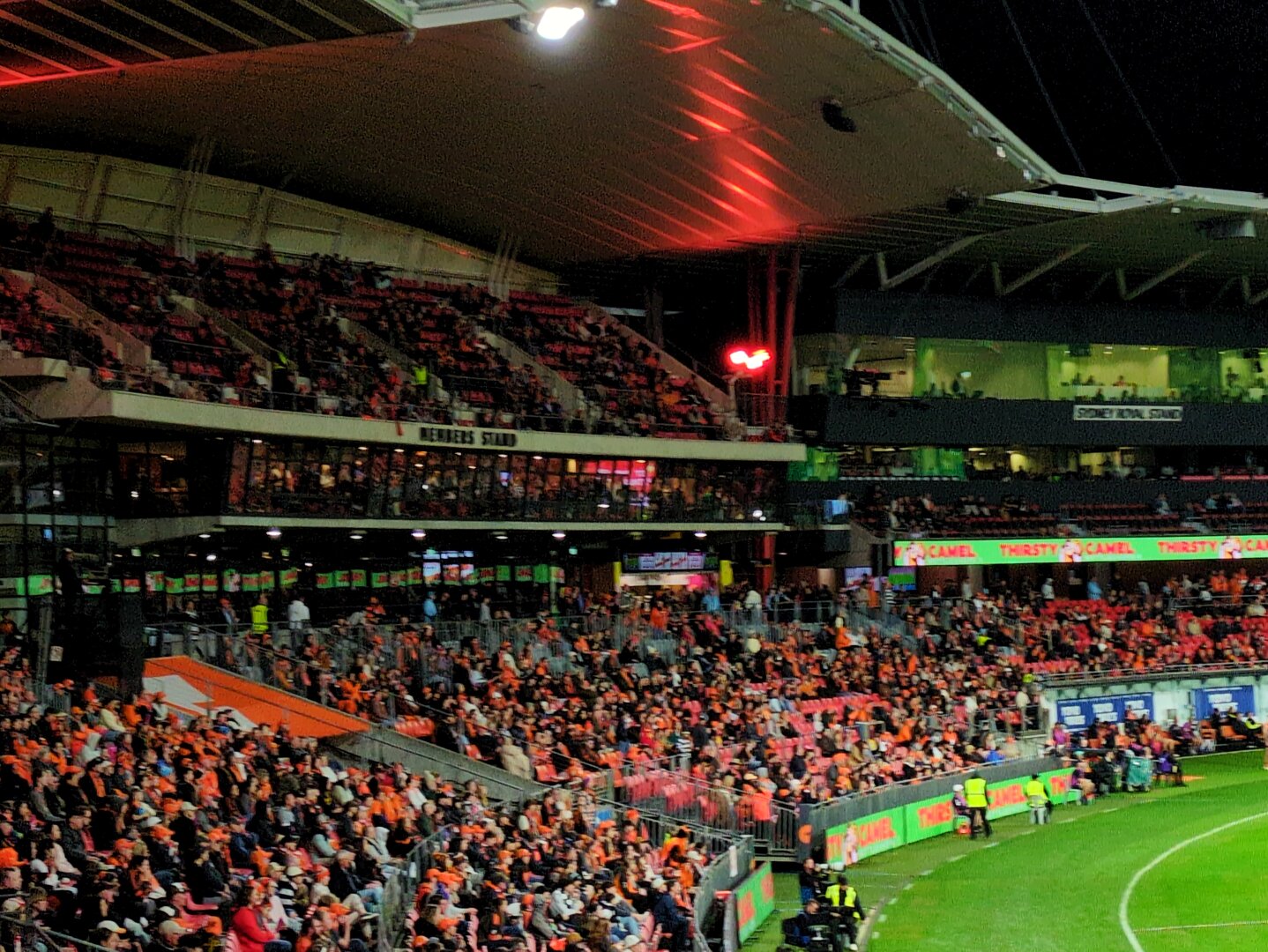 A very full grandstand with many people wearing orange.