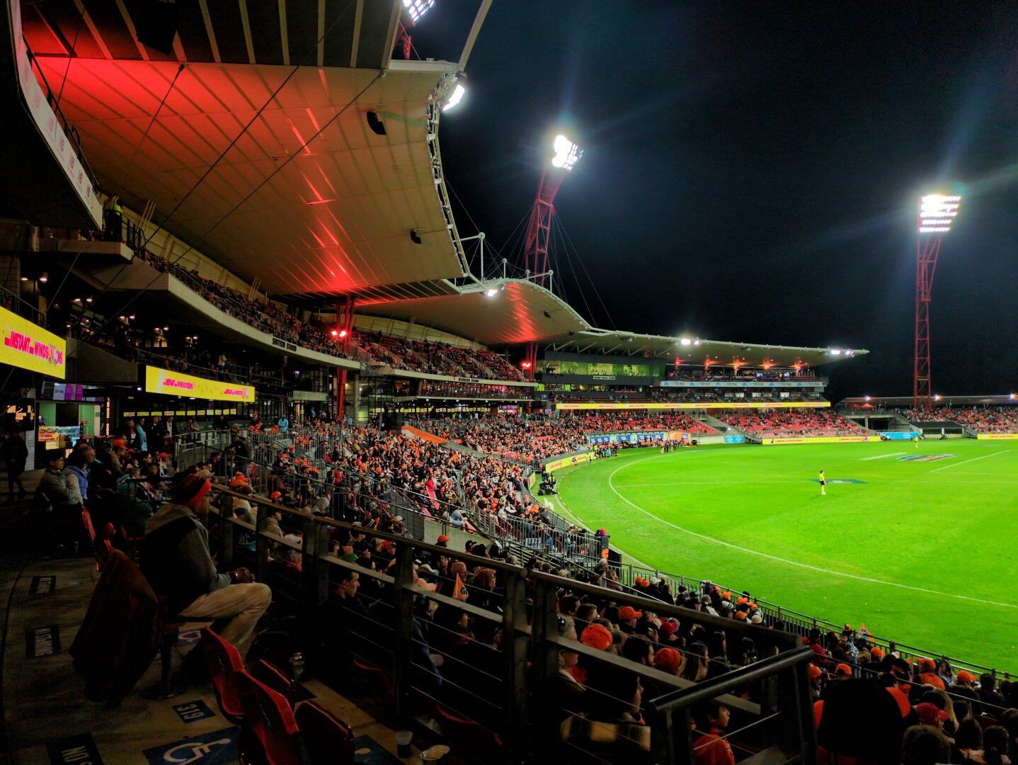A large crowd of people in a stadium wearing orange and watching football.