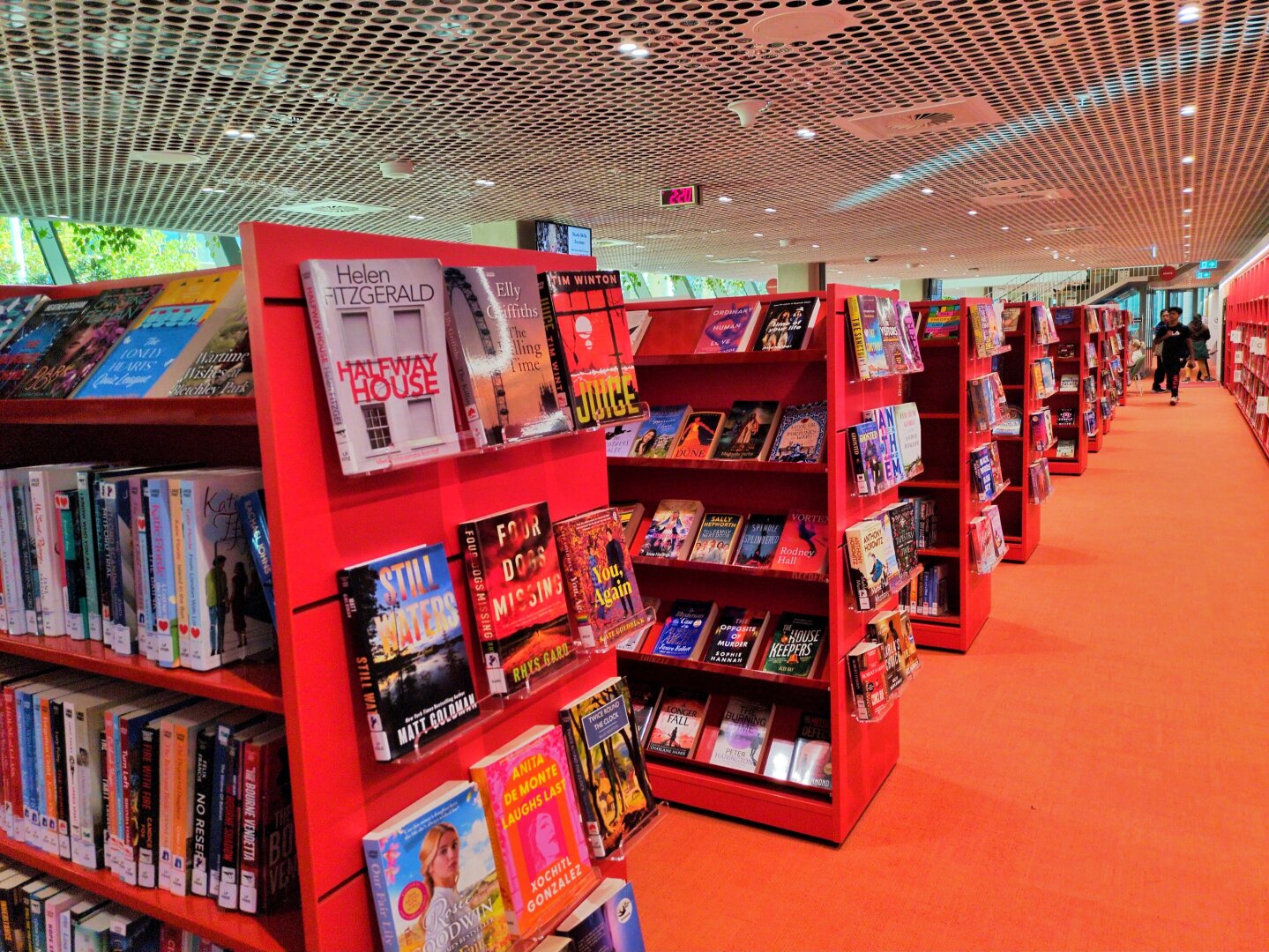 Rows of red bookshelves with red carpet.