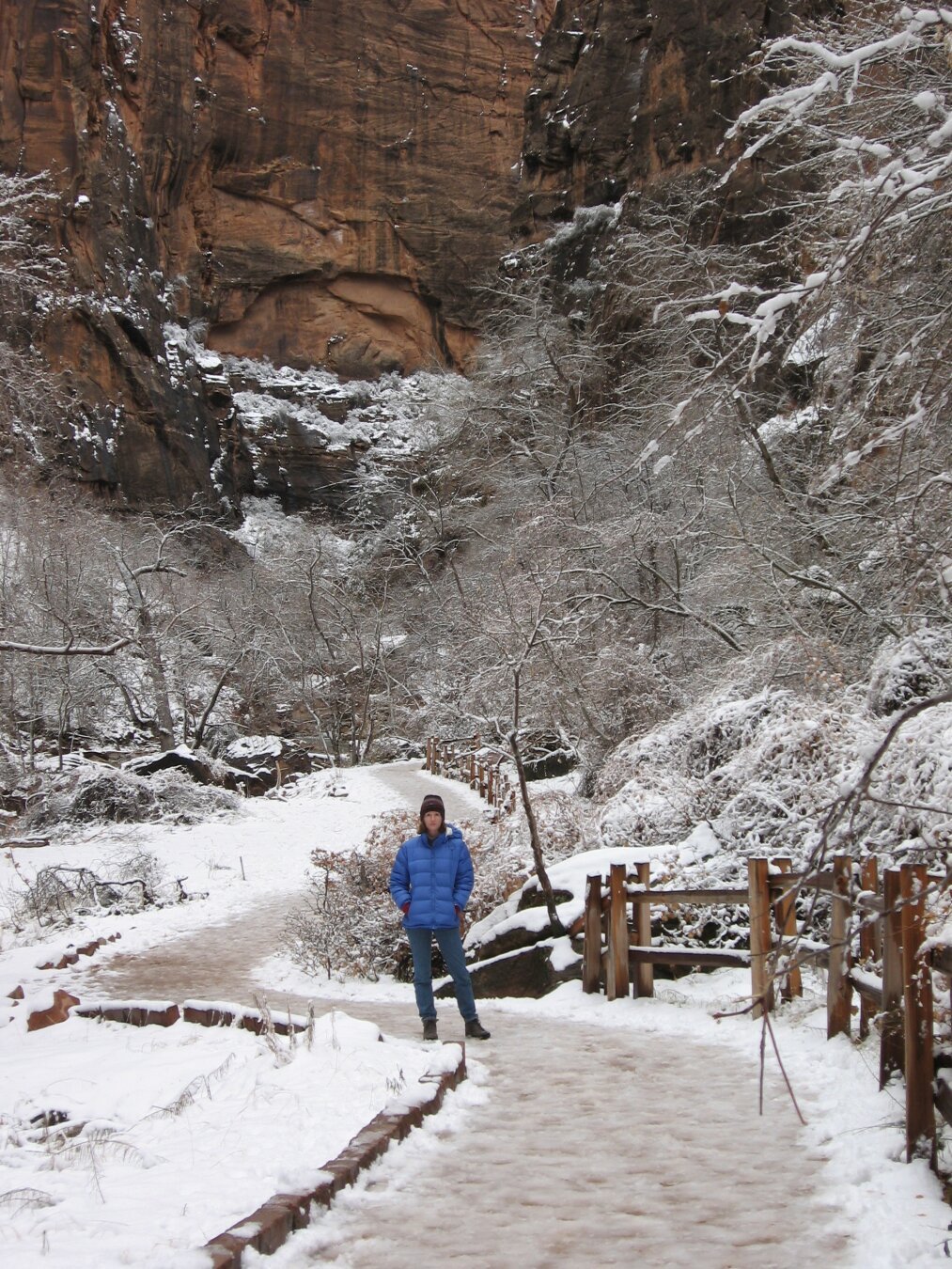 Snowy desert scene, I'm bundled in a parka and snow covers the red rock desert scenery.
