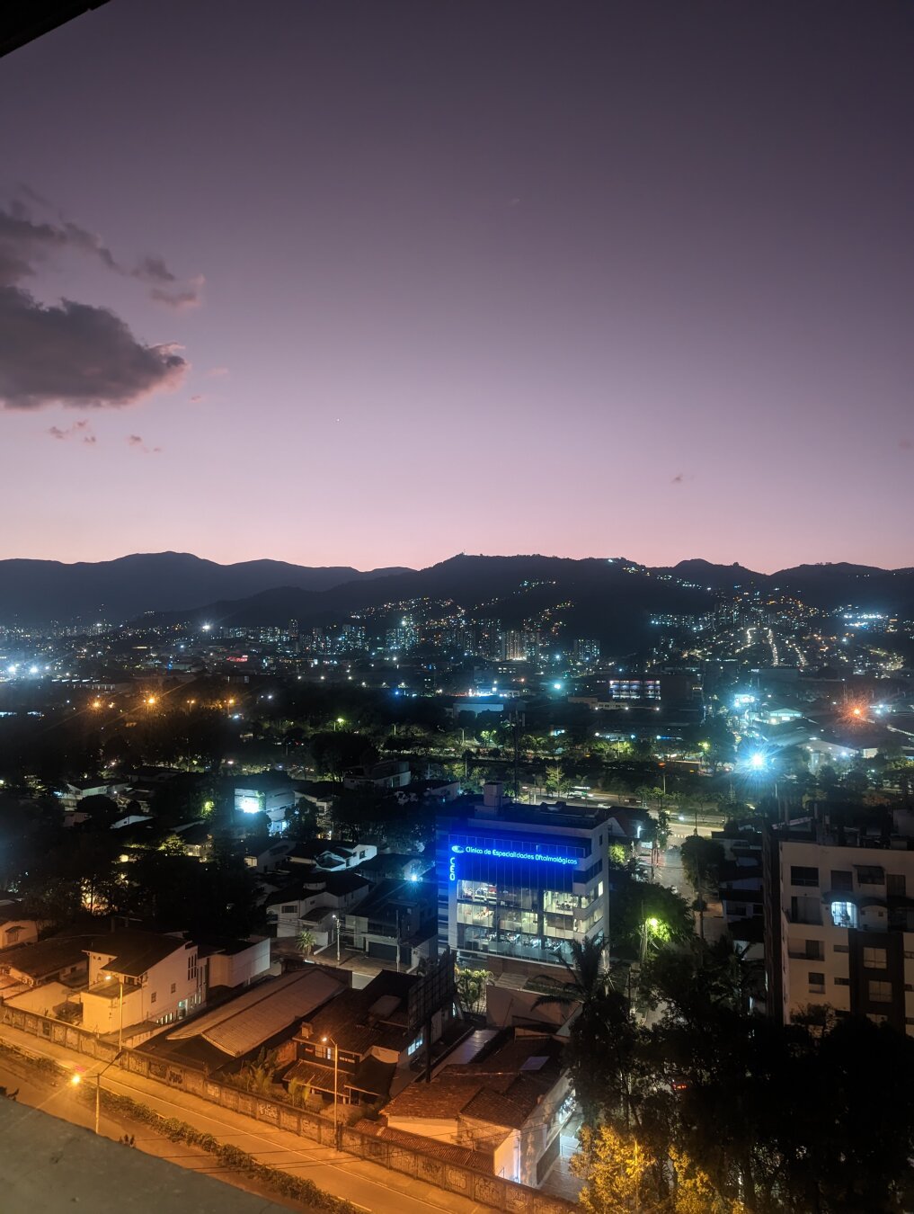 The lights of Medellin as the sun sets behind the hills to the west of the city.