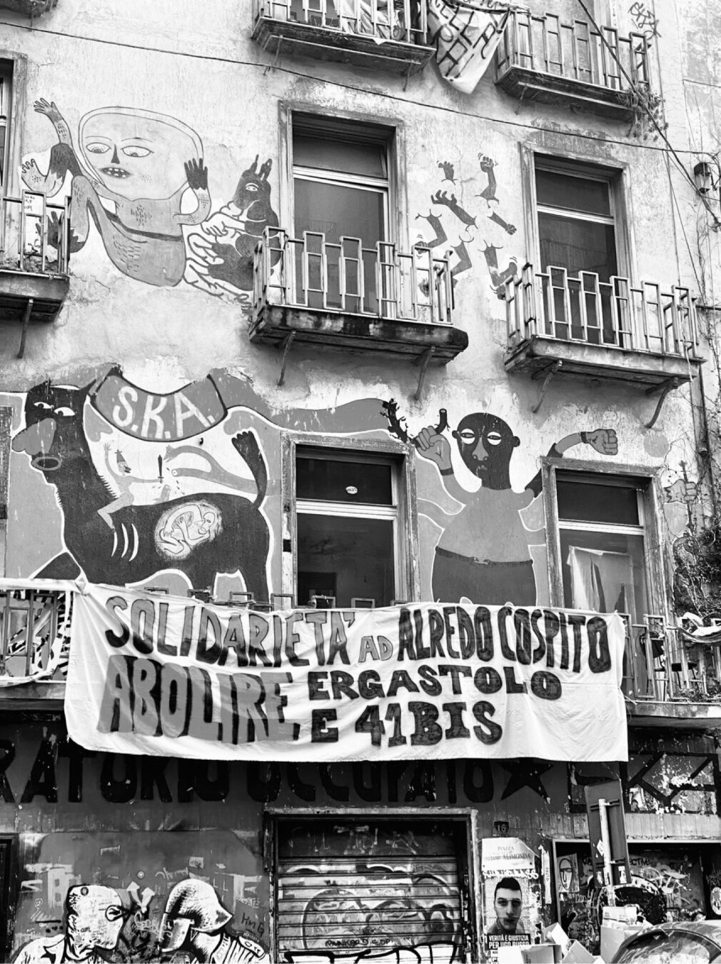 Building facade with a fabric banner holding that reads: Solidarity with Alfredo Cospito. Abolish life imprisonment and 41bis