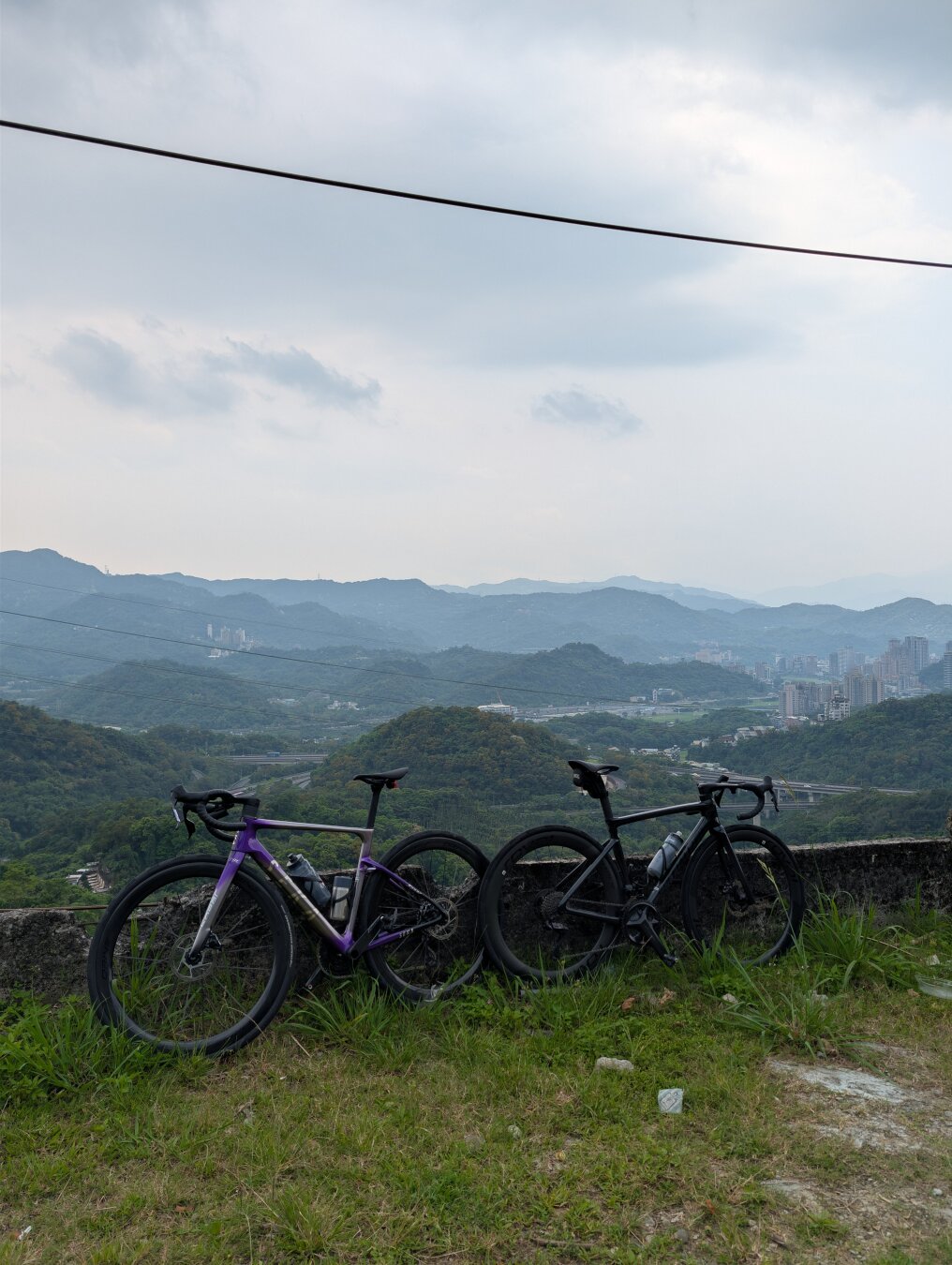 Two roadbikes in front of a mountainous background