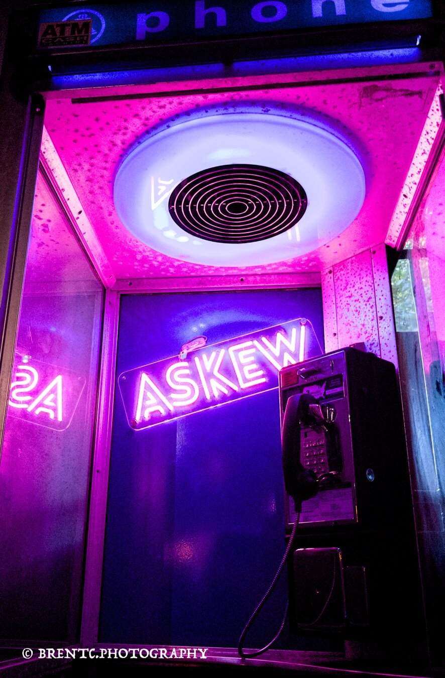 Old phone booth in a music club called Askew in Providence Rhode Island with purple neon sign 