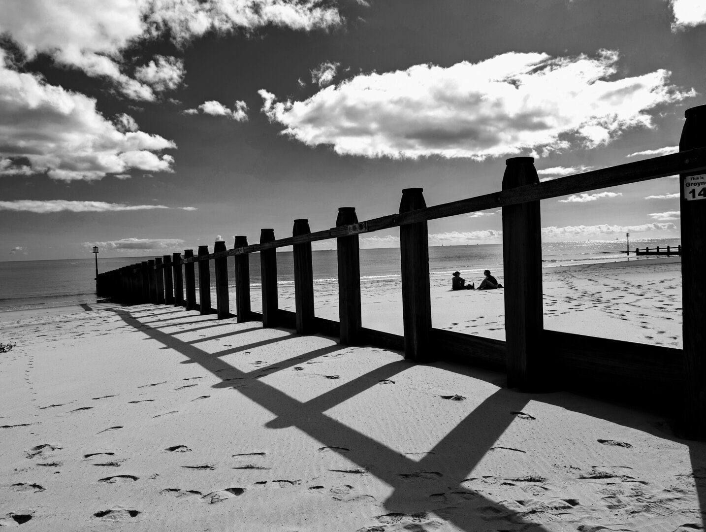 Beach scene with two people framed by beach gates